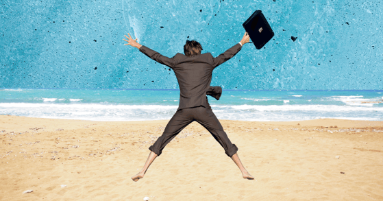 A man in a suit jumping on the beach 