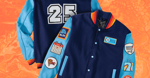 A blue Aldi-branded varsity jacket with the number 25 on it. Patches feature a calendar, Aldi's logo, a spice of pizza, and a shopping cart.