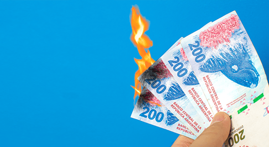 A hand holds burning banknotes marked 