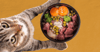 A cat with a bowl of food