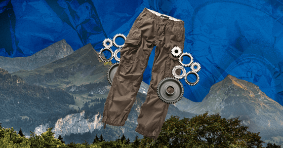 A pair of cargo pants with silver gears around them in front of a mountainscape. 