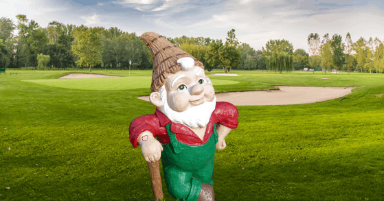 A garden gnome figure on a golf course.