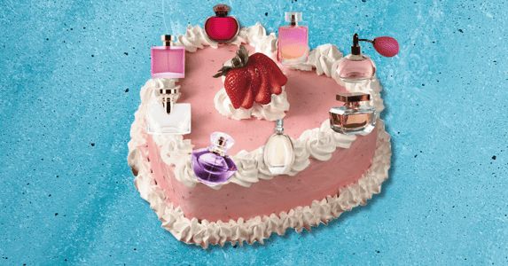 A heart-shaped cake with perfume bottles on the icing. 