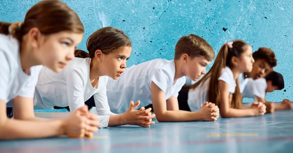 Children doing planks on a gym floor. 