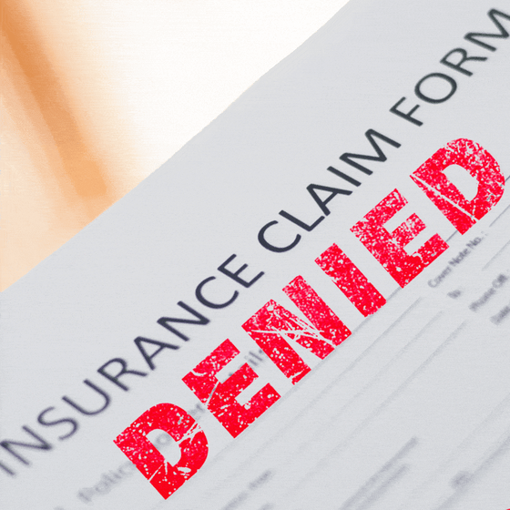 An eraser removes a 'Denied' stamp from an insurance claim form.