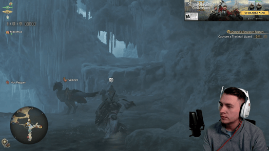 A screenshot of a white man wearing a gray jacket and white headphones live streaming a video game. An ad for another game appears in the corner.