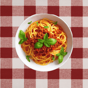 A plate of spaghetti on a red-checkered tablecloth with an ear emerging from either side.