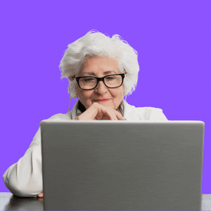 A woman with white hair at a laptop 