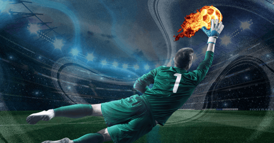 A soccer player in a green uniform intercepts a flaming soccer ball.