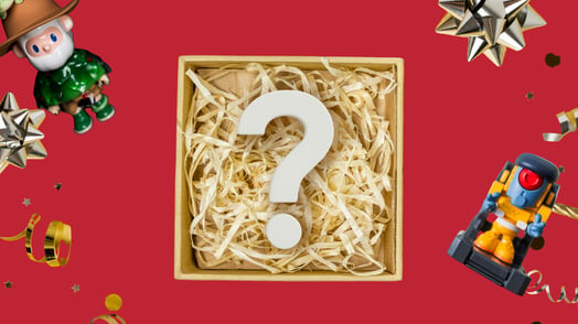 A box full of straw and a question mark surrounded by toys.