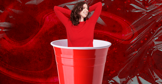 A white, brunette woman in a red sweater emerging from a red Solo cup. 