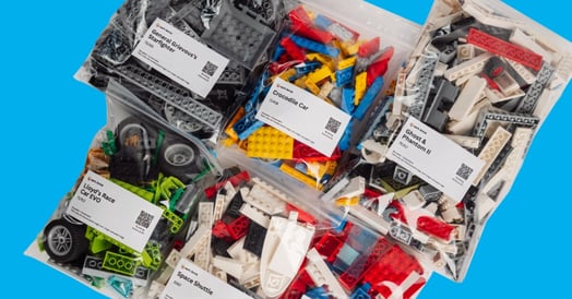 Several plastic bags containing Lego sets. 