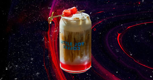 A raspberry danish latte from Little Joy Coffee in a branded glass. (Little Joy Coffee)