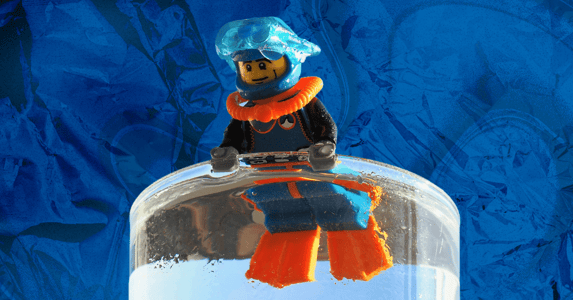 A Lego diver in a cup of water.