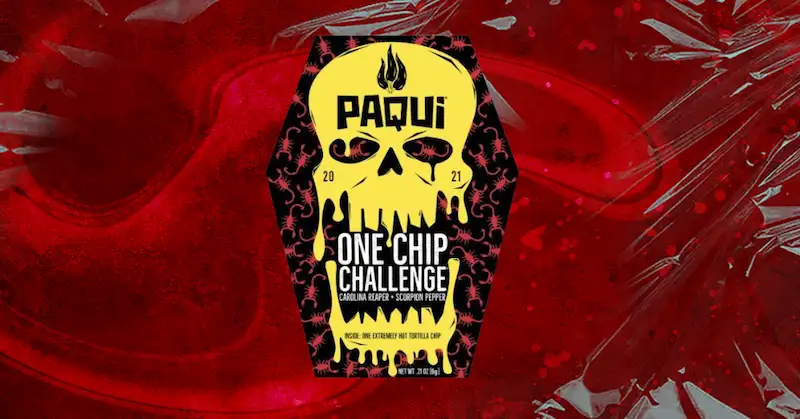 A red coffin-shaped package with a yellow skull on it, reading “Paqui” and “One Chip Challenge” on a red background.